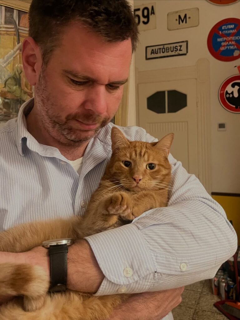 Dávid Vitézy sostiene en brazos a su gato Henry.
