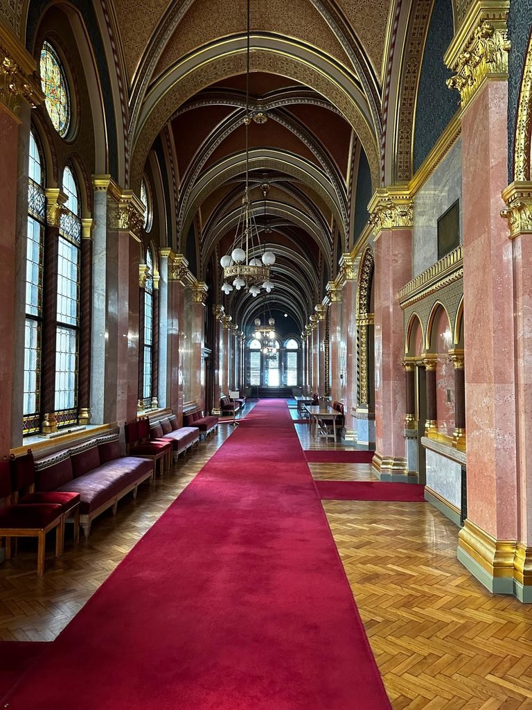 Corredor ceremonial con alfombra roja y detalles dorados en el Parlamento de Budapest