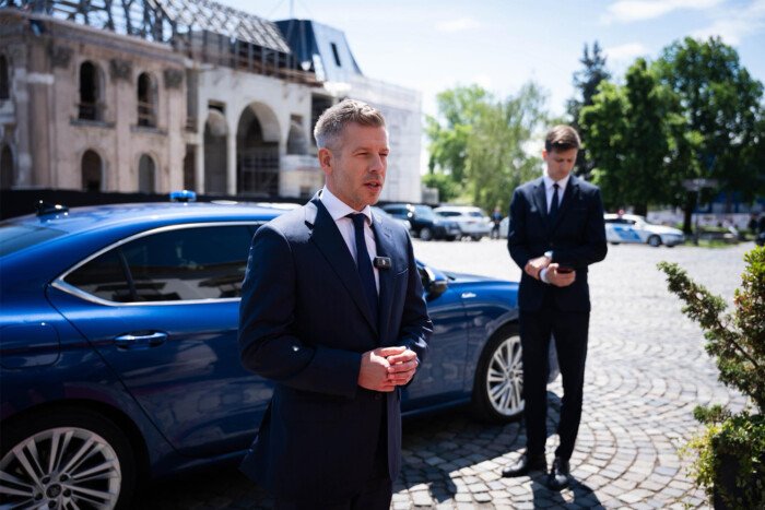 Péter Magyar junto a su Škoda Superb azul, utilizado como coche oficial