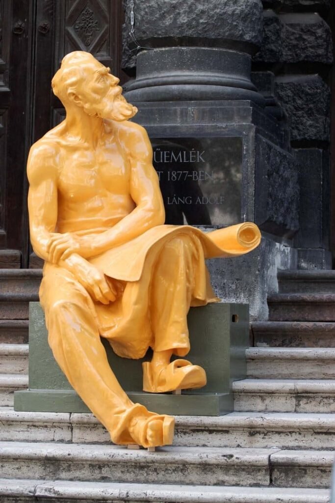 Pospischil Mihály, reproducido mediante impresión 3D a partir de una figura de Alajos Stróbl, sentado en las escaleras de la Universidad Húngara de Bellas Artes, en la avenida Andrássy de Budapest.