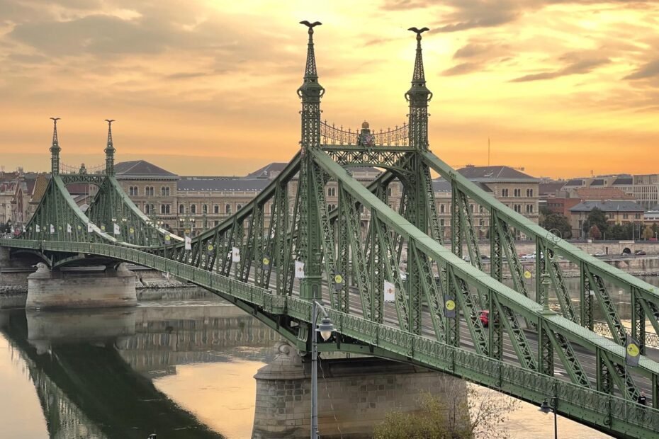 Vista completa del Puente de la Libertad de Budapest iluminado por la luz dorada del amanecer