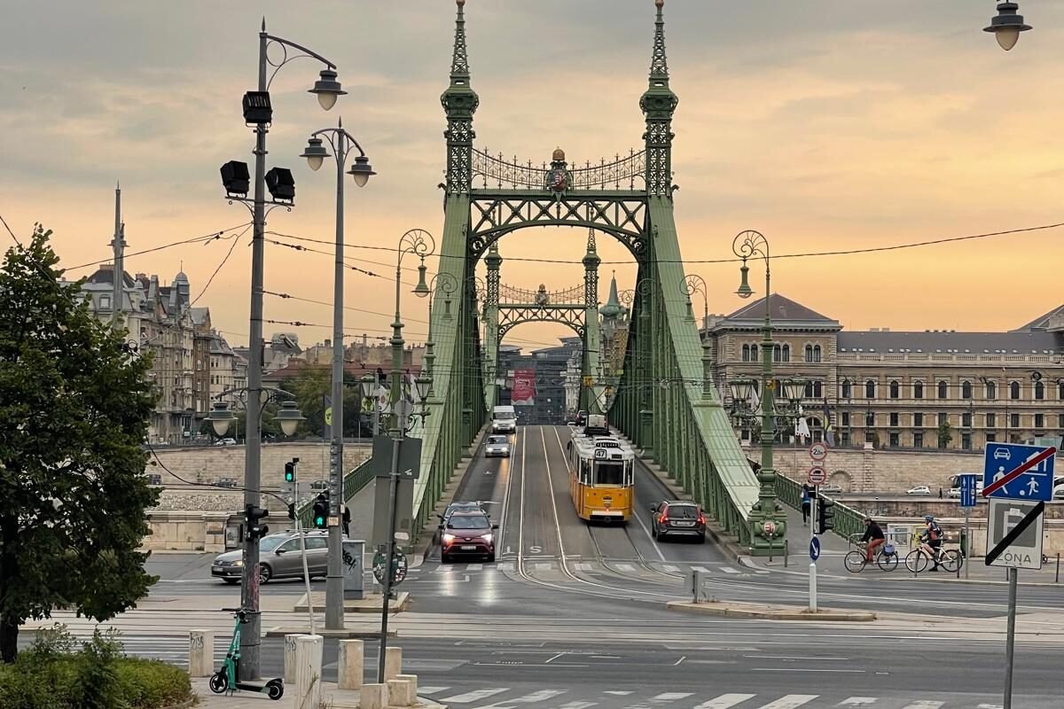 Puente de la Libertad de Budapest al amanecer con el tranvía 47 hacia Pest. Al fondo, a la derecha, la Universidad Corvinus.