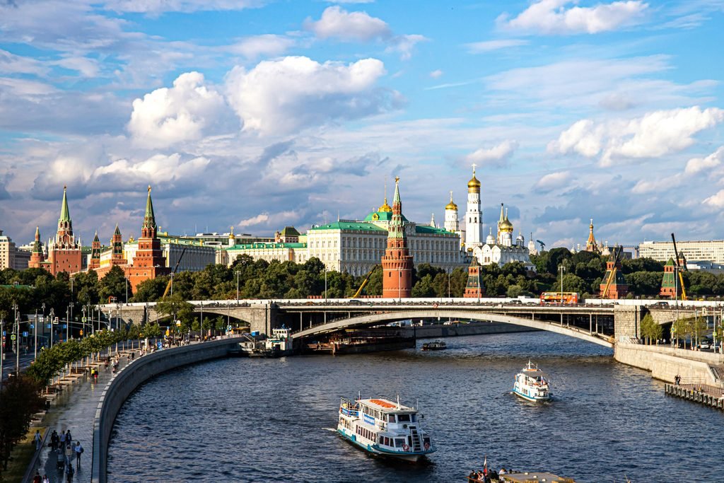 Vista del Kremlin de Moscú junto al río Moscova, con embarcaciones y edificios del complejo al fondo.
