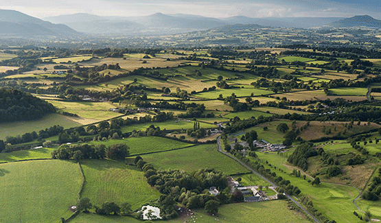 Paisaje rural con campos de cultivo, carreteras y montañas