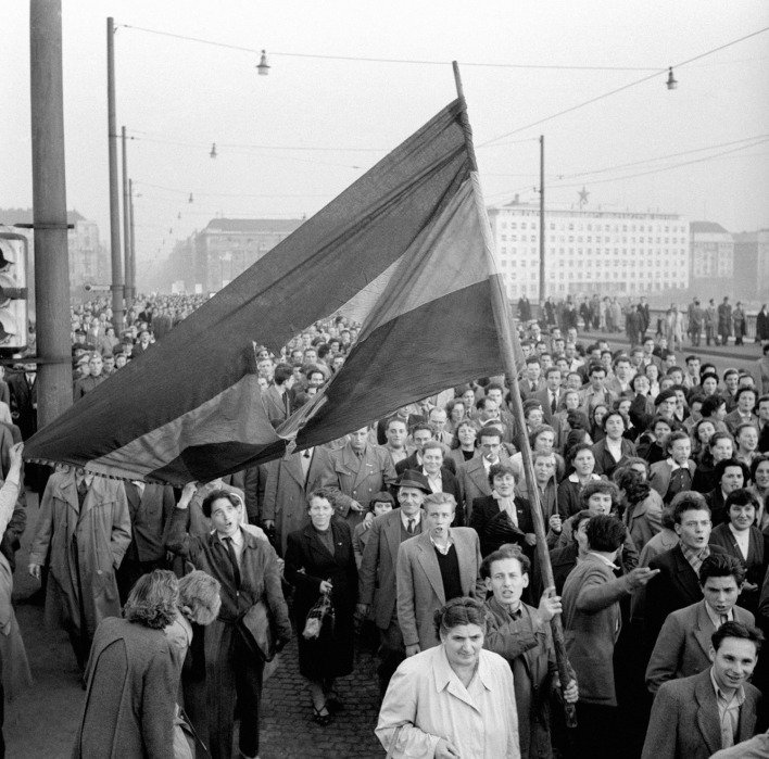 Tüntetők tömege egy nagyméretű lyukas magyar zászlóval a budapesti Margit hídon, 1956. október 23-án.
